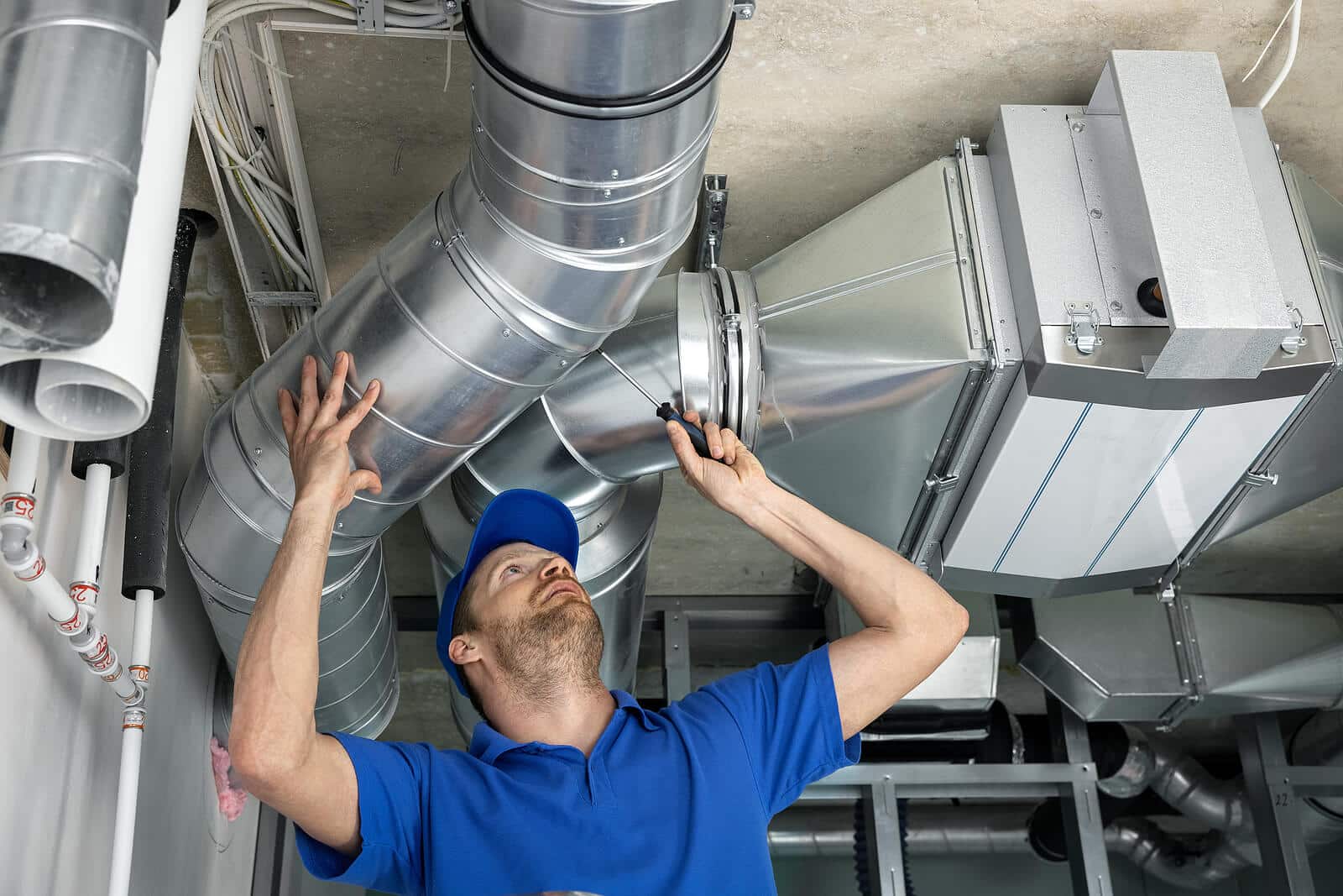 HVAC technician inspecting and repairing air ducts in San Mateo
