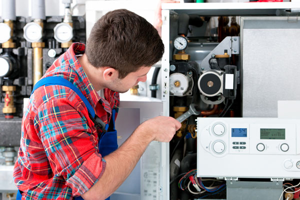 Heating technician repairing boiler controls in San Mateo