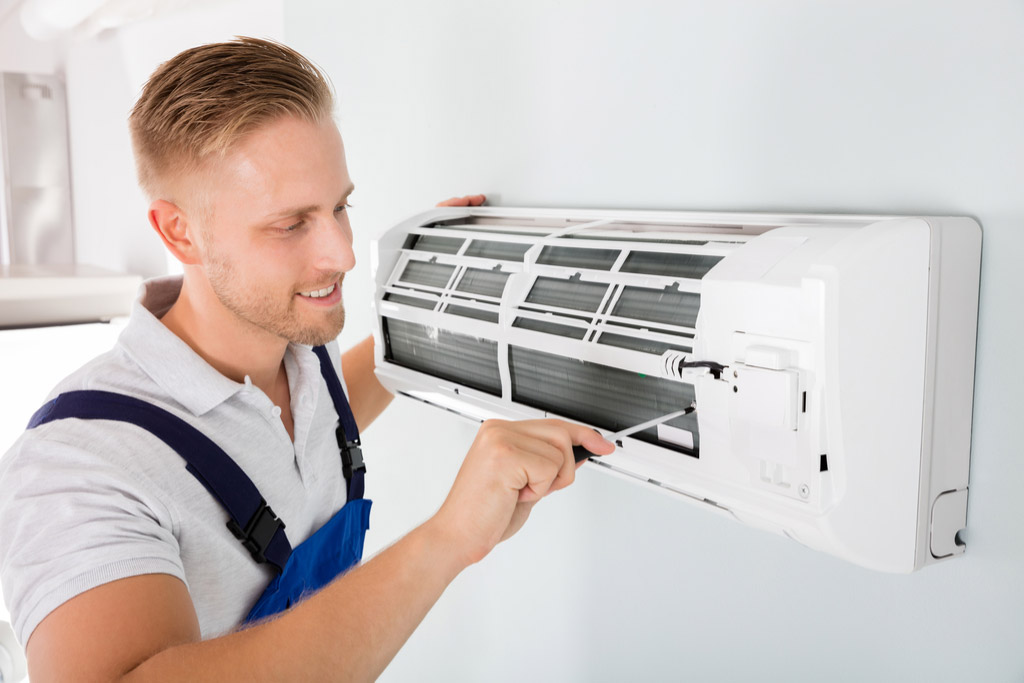 HVAC technician maintaining a ductless air conditioner in San Mateo