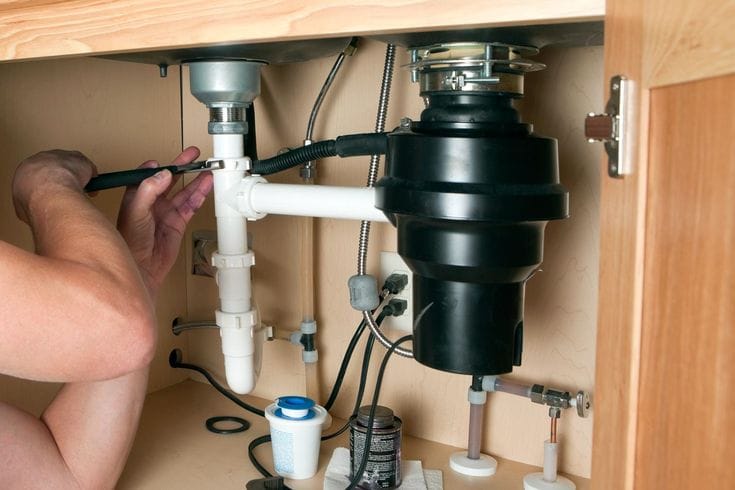Plumber repairing a garbage disposal in San Mateo