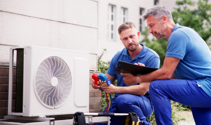 HVAC technicians installing an outdoor air conditioning unit in San Mateo